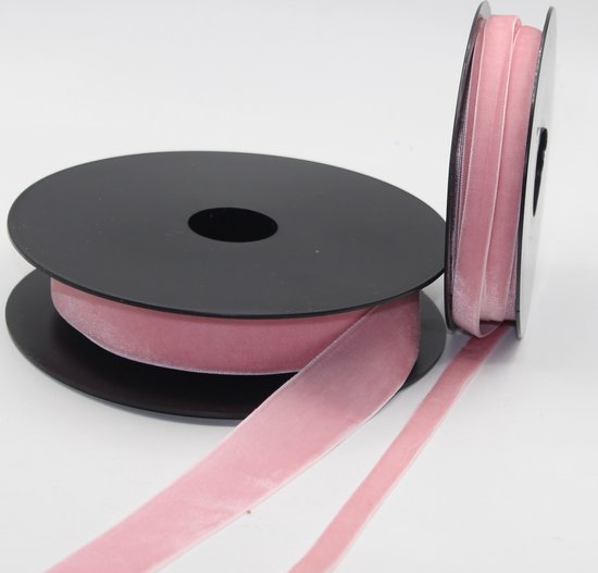 Deux rouleaux de ruban de velours rose, dont un déroulé.