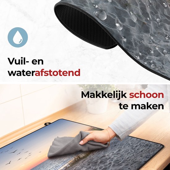 Een close-up van de inductiebeschermer die vuil- en waterafstotend is. Een hand maakt de beschermer schoon met een doekje.