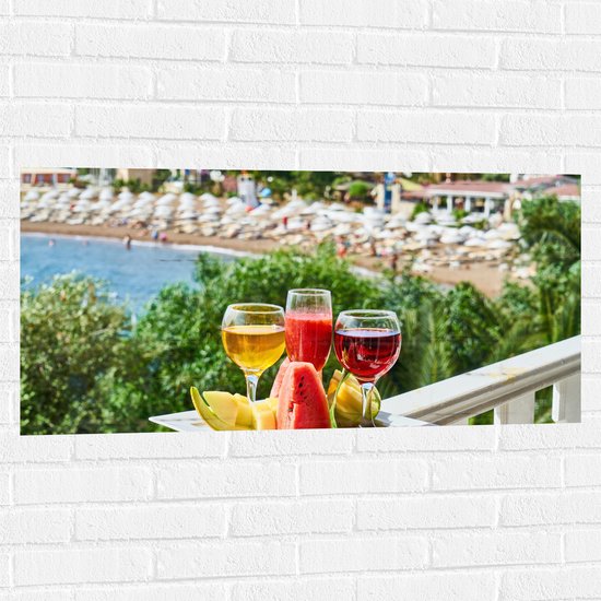 Muursticker - Gekleurde Drankjes met Stukken Fruit en Uitzicht op een Baai - 100x50 cm Foto op Muursticker