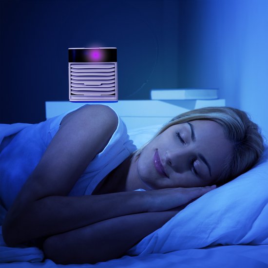 Een blonde vrouw slaapt vredig, met een kleine witte mini-aircooler met paarse LED-verlichting boven haar.