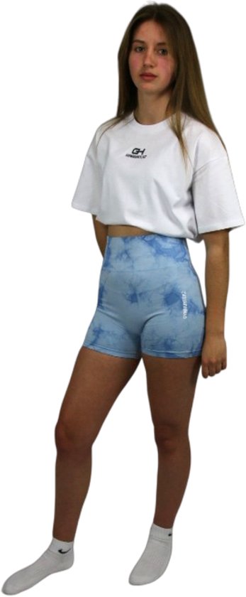 Model draagt een lichtblauwe tie-dye sportshort met hoge taille en een wit GYMHUNTERZ-t-shirt.