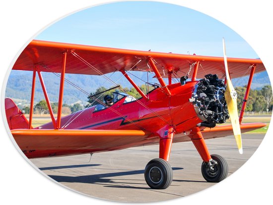 PVC Schuimplaat Ovaal - Rood Stuntvliegtuig Opstijgend vanuit Vliegbasis - 28x21 cm Foto op Ovaal (Met Ophangsysteem)
