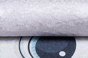 Gros plan de la texture d'un tapis rose à côté d'un grand œil de chat bleu.