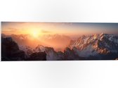PVC Schuimplaat- Zon Zakkend achter Besneeuwde Bergen - 90x30 cm Foto op PVC Schuimplaat