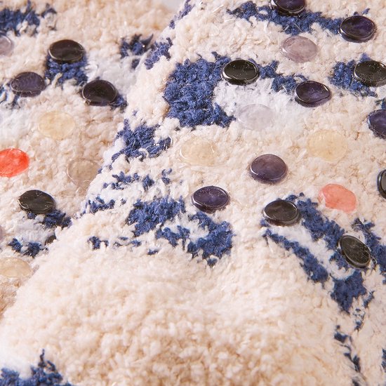 Close-up van de textuur van de sokken met noppen, met een witte, blauwe en grijze print.