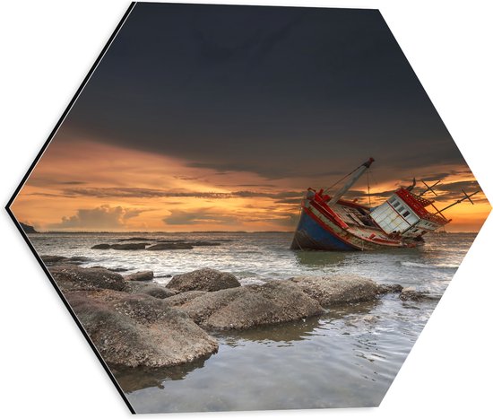 Dibond Hexagon - Zakkend Scheepswrak bij Rotsen in de Zee bij Zonsondergang - 40x34.8 cm Foto op Hexagon (Met Ophangsysteem)