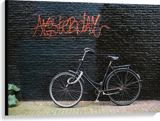 Canvas - Fiets geparkeerd tegen Muur met Tekst ''Amsterdam'' - 100x75 cm Foto op Canvas Schilderij (Wanddecoratie op Canvas)