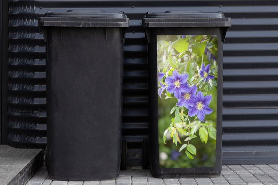 Zwarte kliko met een sticker van paarse clematisbloemen, naast een andere zwarte kliko.