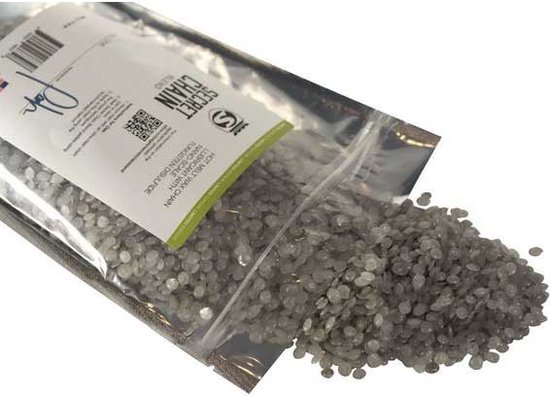 Zilveren zakje met "SECRET CHAIN BLEND" en grijze korrels die eruit vallen.
