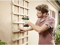 Man met bril en Bosch EasyDrill 18V-40 accuboormachine boort in een houten klimrek.