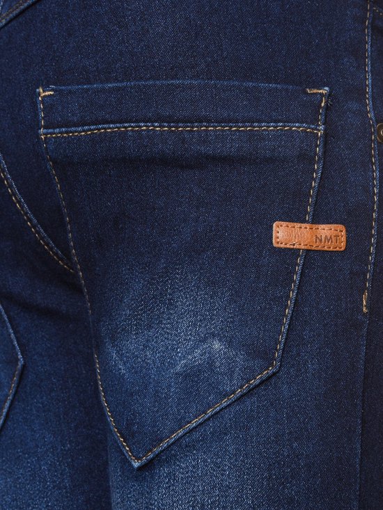 Close-up van een donkerblauwe jeans van Name It, met een bruin label met 'NMT' erop.