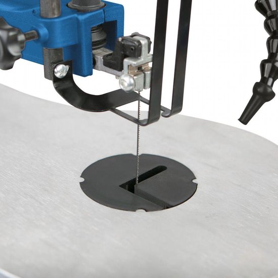 Close-up van het zaagblad, de werktafel en de flexibele stofblazer van een figuurzaagmachine.