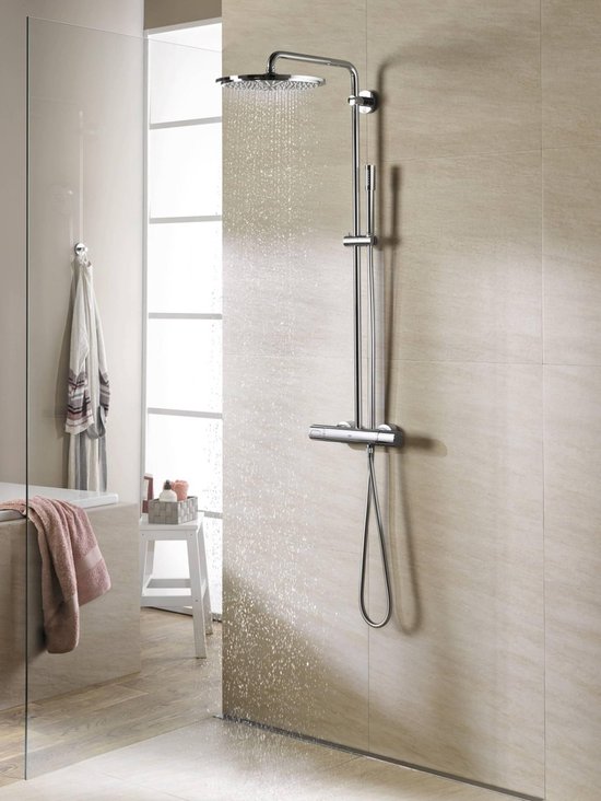 Douche in moderne badkamer met tegelwanden en glazen afscheiding, douchekop sproeit water.