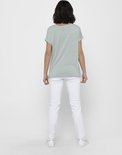 Model van achteren gezien in een mintgroen en wit gestreept t-shirt met omgerolde mouwen.