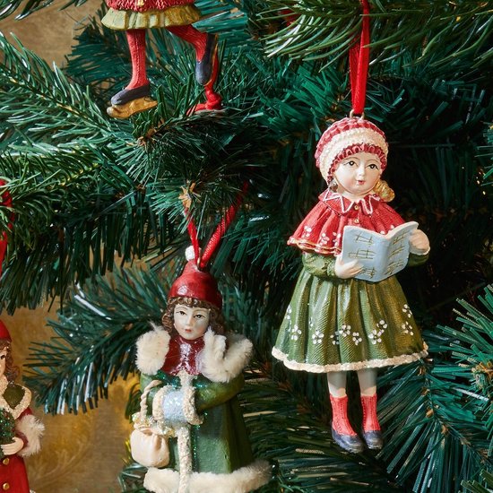 Drie nostalgische kersthangers in rood en groen, hangend in een kerstboom.