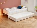 Wit houten dagbed met onderschuifbed, twee kussens en beddengoed met geometrische print.