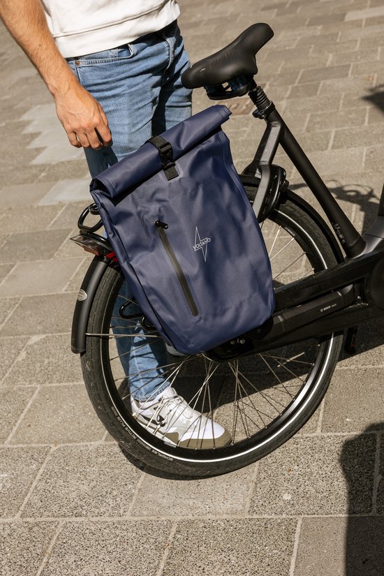 Donkerblauwe Voltano fietstas, bevestigd aan een fiets met een ritssluiting aan de voorkant.