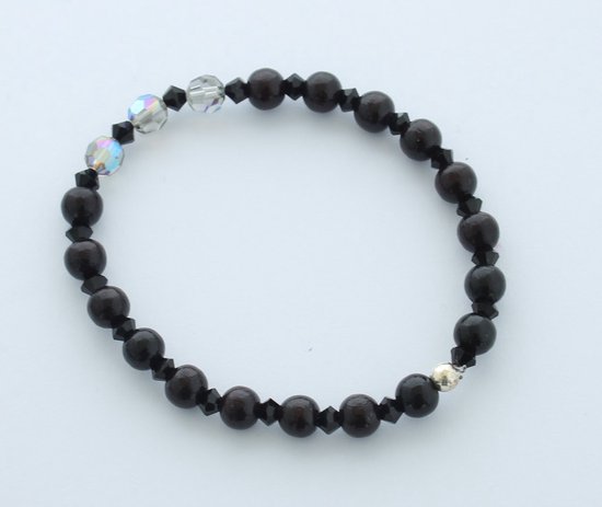 Elastische armband met zwarte houten kralen en doorschijnende kristallen accenten.