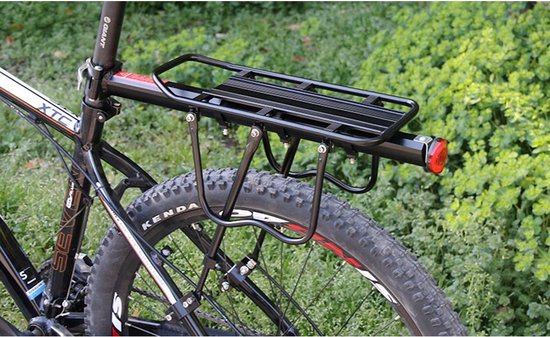Zwarte fietsbagagedrager met rode reflector, gemonteerd op de achterkant van een fiets.