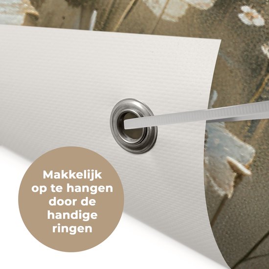 Close-up van een tuinposter met witte bloemen, die het ophangen aan ringen laat zien.