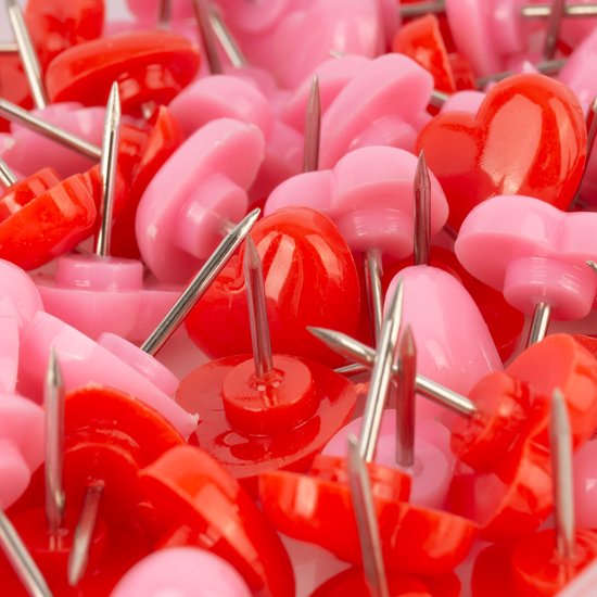 Een close-up van rode en roze hartvormige punaises.