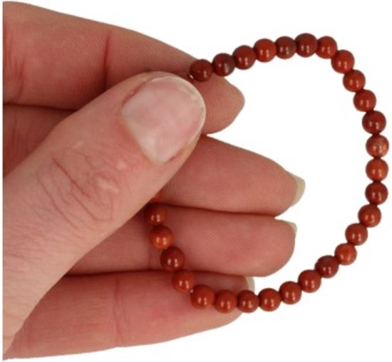 Een rood jaspis kinderarmbandje van 4 mm, met kralen, vastgehouden in een hand.