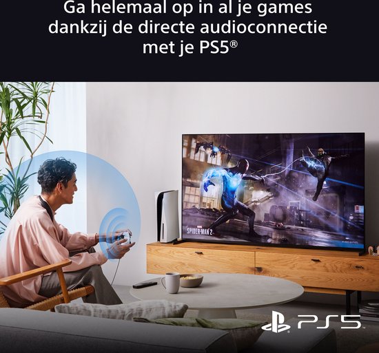 Man met een koptelefoon die een PS5-controller vasthoudt, naast een TV met Spider-Man.