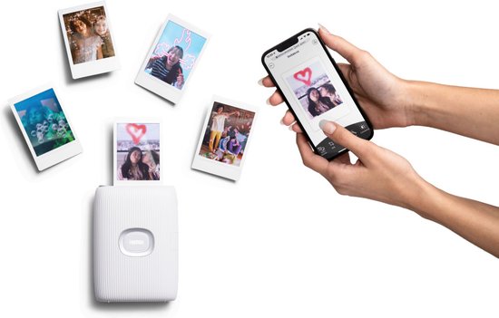 Handen houden een smartphone vast met een Instax foto-app. Naast de smartphone een witte Instax Mini Link 2 printer, met een foto van twee personen met een hartje erop.