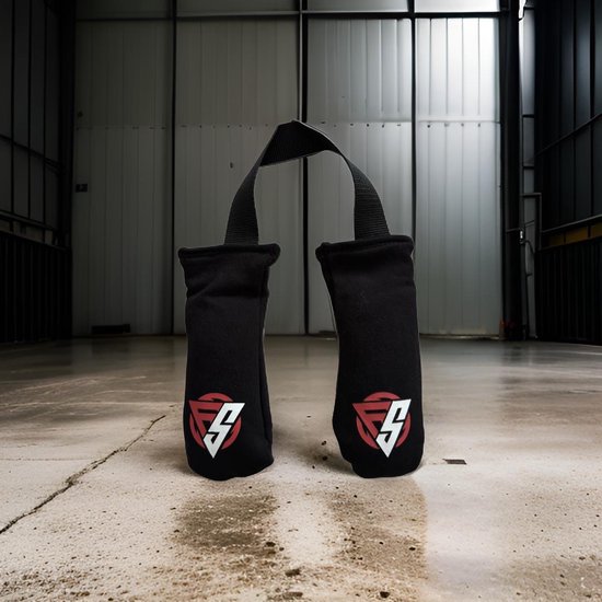 Zwarte geurvreter voor bokshandschoenen met draaglus en rood/wit logo, staand op een betonnen vloer.