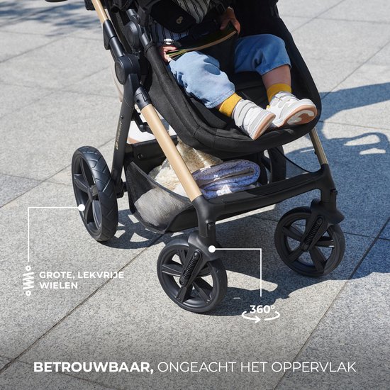 Close-up van de grote, lekbestendige wielen van een zwarte kinderwagen op een betegeld oppervlak.
