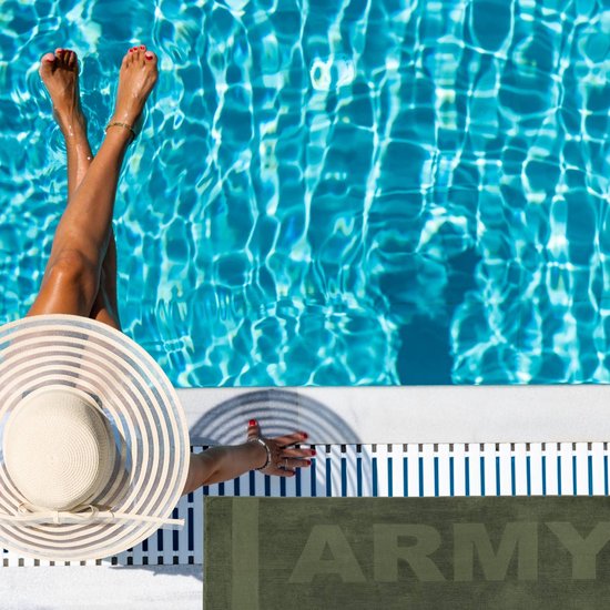 Vrouw met strooien hoed en groen "ARMY" strandlaken bij een zwembad