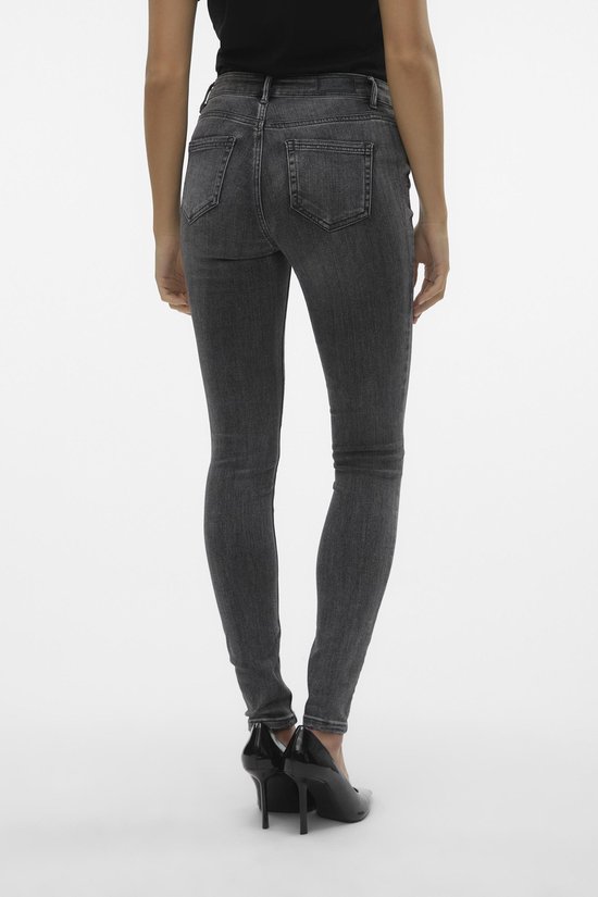 Achterkant van een model in strakke grijze jeans met hoge taille.