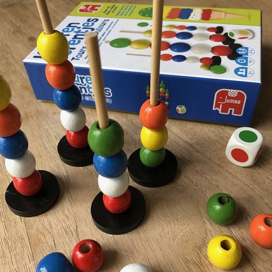 Close-up van Kleurentorentjes spel op een houten tafel met opgestapelde torentjes en losse kralen.