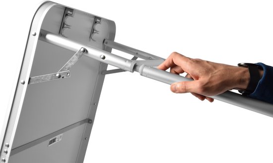 Hand die een verstelbare poot van de zilverkleurige campingtafel uitschuift.