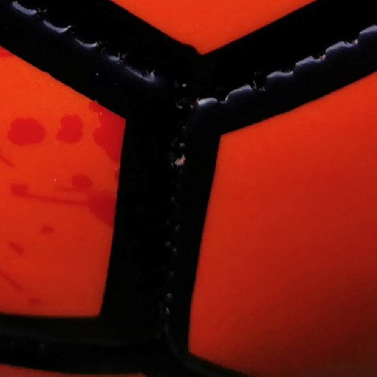 Detail van de naden van een oranje voetbal met zwarte vlakken.