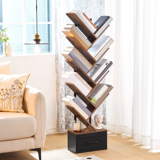 Boekenkast in boomvorm met houten takken, gevuld met boeken, in een lichte woonkamer met een bank en een raam.