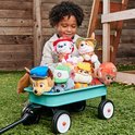 Een jongen met een krullende haar, met een wagentje vol PAW Patrol-knuffels.