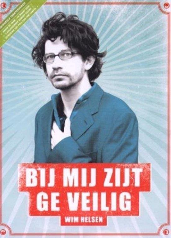 Een man met bril en warrig haar draagt een blauw colbert. De tekst "BIJ MIJ ZIJT GE VEILIG" staat op de voorgrond.