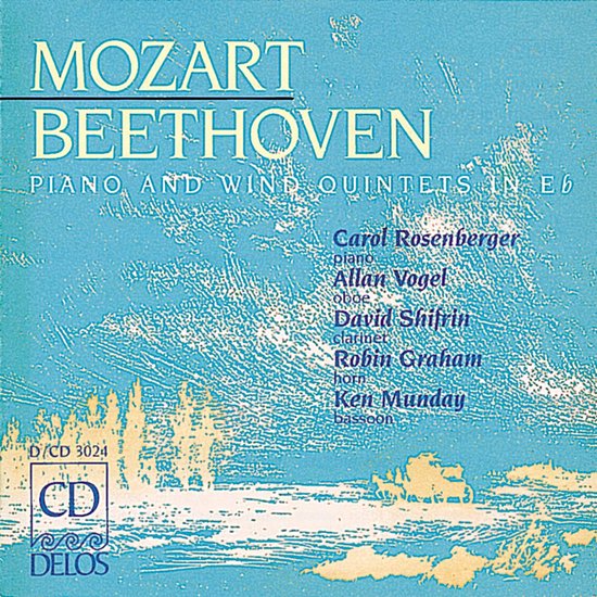 Boek met de titels "MOZART BEETHOVEN" en "PIANO EN WIND KWINTETTEN IN Eb" op een blauwe achtergrond met landschapsdetails.