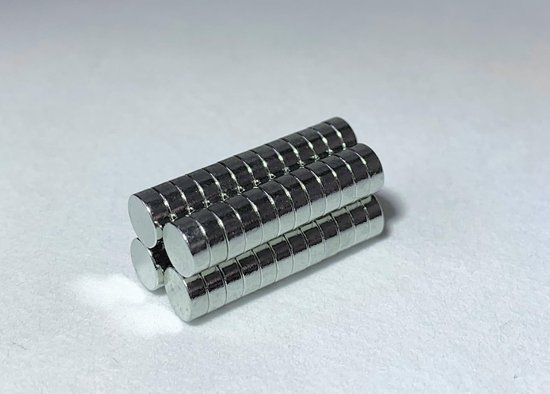 Vier gestapelde zilverkleurige magneten, gerangschikt in een vierkant op een witte ondergrond.
