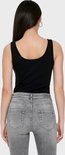 Achterkant van een model in een zwarte tanktop en grijze jeans.