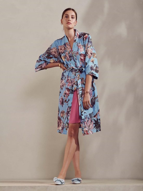 Model in een blauwe kimono met bloemenprint en roze onderjurk. Gevlochten riem in de taille.