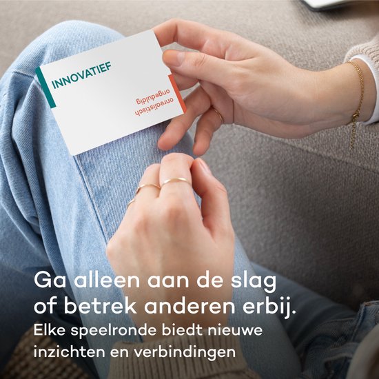 Hand met ringen houdt kaart met "INNOVATIEF" en "ongeduldig onrealistisch".
