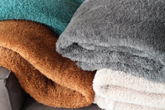 Stapel plaids in de kleuren grijs, bruin en groenblauw.
