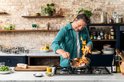 Jamie Oliver kookt op gas met een pan met vlammen.