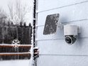Eufy 4K camera met zonnepaneel op een besneeuwde gevel.