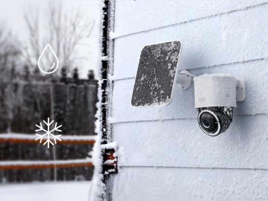Eufy 4K camera met zonnepaneel op een besneeuwde gevel.