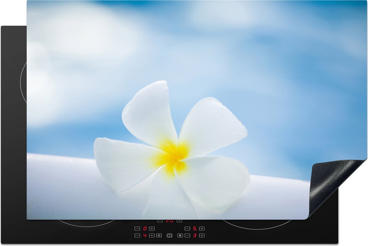 KitchenYeah® Inductie beschermer 81x52 cm - Knalblauwe lucht boven een Plumeria bloem - Kookplaataccessoires - Afdekplaat voor kookplaat - Inductiebeschermer - Inductiemat - Inductieplaat mat