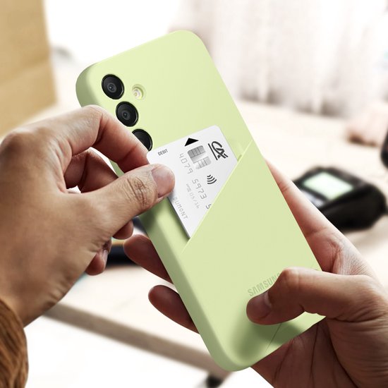 Handen plaatsen een pasje in het lichtgroene Samsung telefoonhoesje met sleuf voor pasjes.