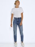 Model in een blauwe jeans met een stonewashed effect, rechte pasvorm en enkellengte.
